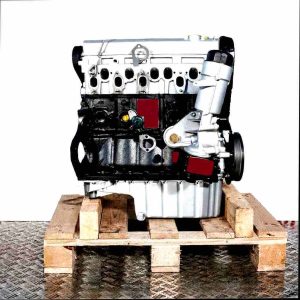 Side view of an AVR engine on a wooden pallet against a white background. The engine block is black, the cylinder head silver.