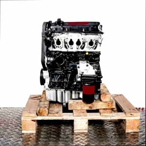 Side view of a black and silver AZM engine on a wooden pallet against a white background. The timing belt is visible.