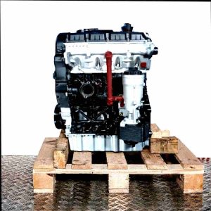 Side view of a BXE engine on a wooden pallet against a white background. The silver and black engine, featuring a yellow oil dipstick, is fully visible.