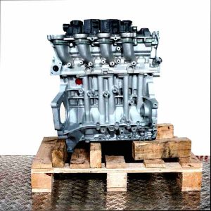 Side view of a D 4164 T engine on a wooden pallet against a white background. The engine block is silver, connected to black components. Intake manifolds are clearly visible.