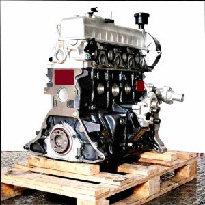 D4BH engine on a wooden pallet against a white background. Black engine block, silver cylinder head. Image of the engine.