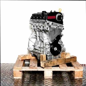 Side view of a DACA engine on a wooden pallet against a white background. The silver engine with black and yellow accents displays features like an oil dipstick and belt.