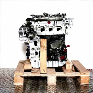 DTSB engine on a wooden pallet against a white background. The black and silver engine with yellow and green accents is viewed from the side.