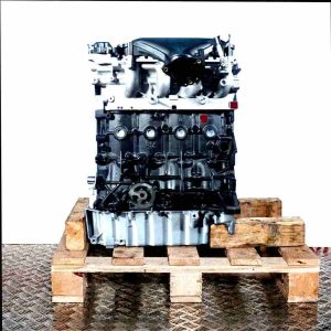 G6DG engine on a wooden pallet against a white background. The black painted engine block and silver cylinder head are visible. Various connectors and brackets are present.