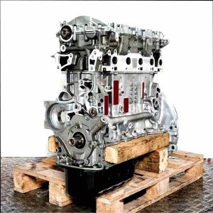 G8DC engine on a wooden pallet against a white background. The metal engine block features various openings and bolt holes. Side view, slightly angled.