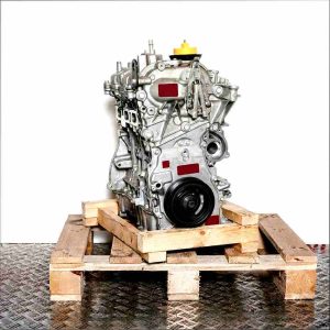 H4B 410 engine on a wooden pallet against a white background. Side view of the complete metal engine with a yellow cap.