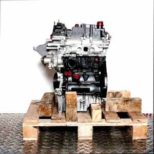 M1DD engine on a wooden pallet against a white background. The silver and black engine with yellow details is vertically oriented.