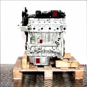 Side view of the T1WB engine on a wooden pallet against a white background. The grey engine with black covers displays details like screws and openings.