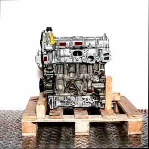 Side view of engine YN2X on a wooden pallet against a white background. The grey-toned engine displays its front, featuring a yellow oil dipstick tab.